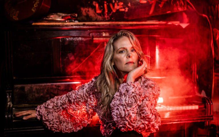 Bilden "Sofia-Karlsson-3.jpg" är ett stämningsfullt och konstnärligt porträtt av Sofia Karlsson i en miljö som andas livemusik och klubbkänsla.