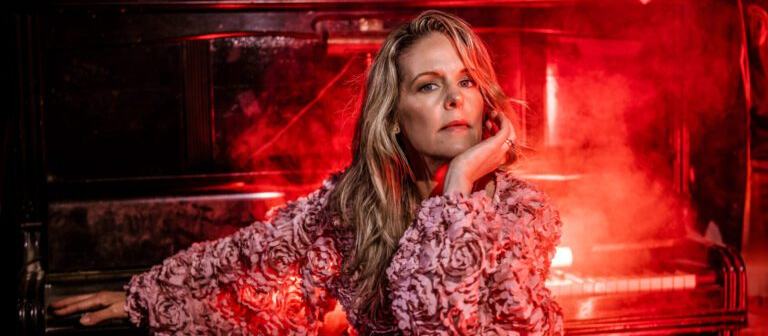 Bilden "Sofia-Karlsson-3.jpg" är ett stämningsfullt och konstnärligt porträtt av Sofia Karlsson i en miljö som andas livemusik och klubbkänsla.